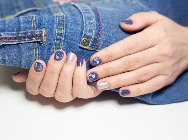 Female hands with professional blue and silver manicure