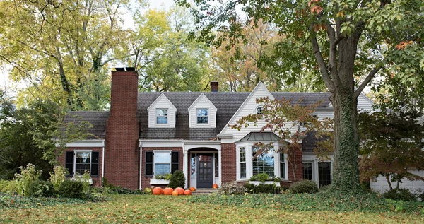 Red Brick House in Wooded Setting with Pumpkins