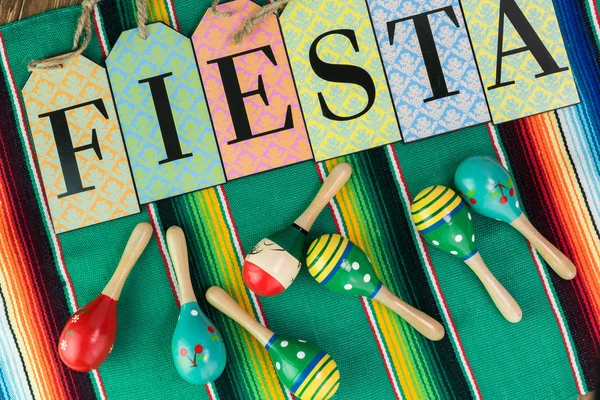 Mexican fiesta table decoration with colorful fiesta maracas and traditional table runner.