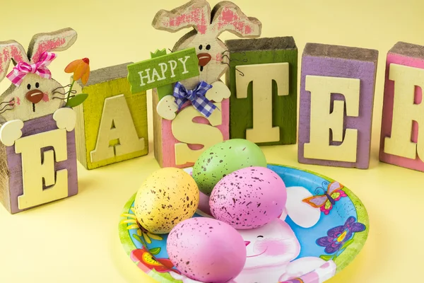 Easter table decoration with easter letters, bunny plate and eggs.