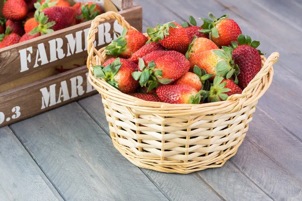 Fresh, ripe srawberries in a basket and in crate of local farmer
