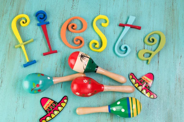 Mexican fiesta table decoration with  colorful painted letters and maracas.