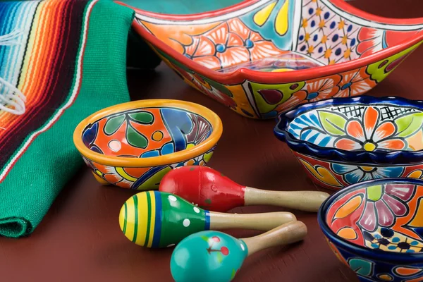 Mexican fiesta table decoration with  colorful bright pottery, maracas and mexican table runner.