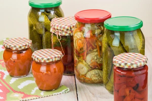 Assorted vegetable pickles in glass jars and roasted red pepper