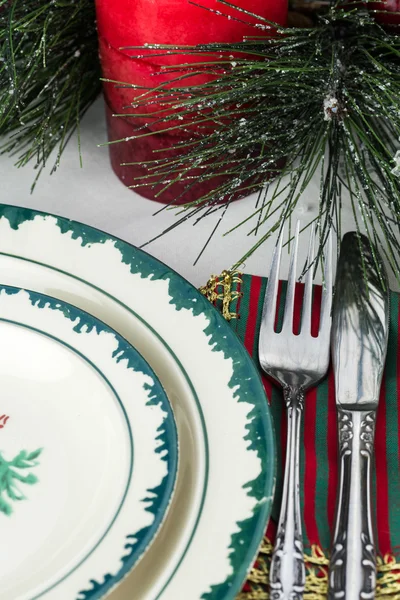 Dinner table set with Christmas dishes.
