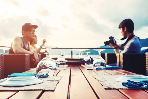 Dinner preparation on desk on the island with friends group in sunset, vintage tone, selective focus on glass