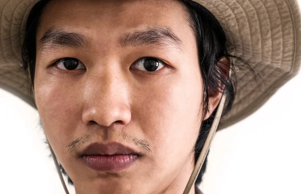 Close-up Asian guy in brown hat with serious face looking at camera