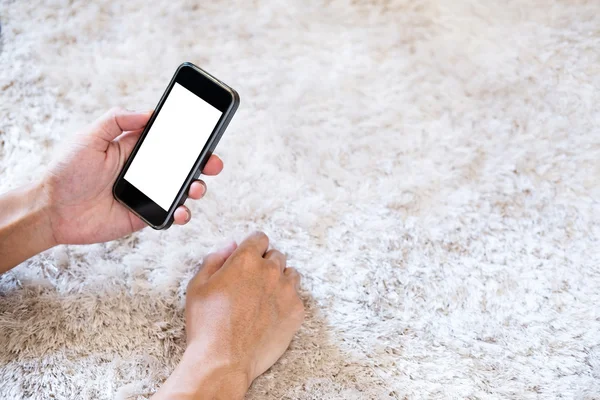 Hand using smart phone on white carpet, selective focus