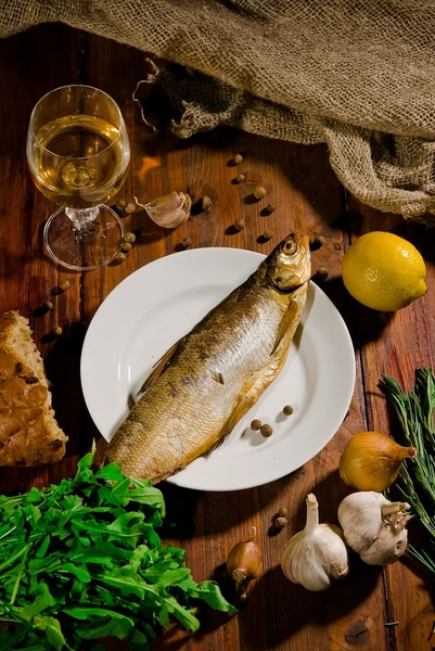 Smoked fish on a platter with green and wine
