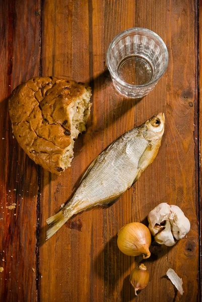 Smoked fish on a platter with bread and hooch