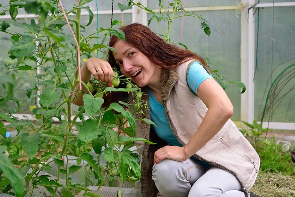 The girl smiles and plays green thumb branch with young