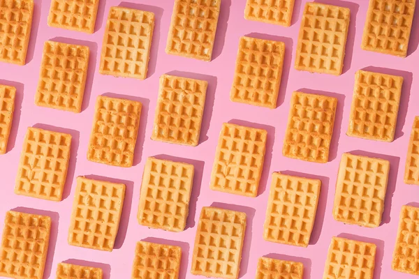 Concept idea. sweet waffles on pink background