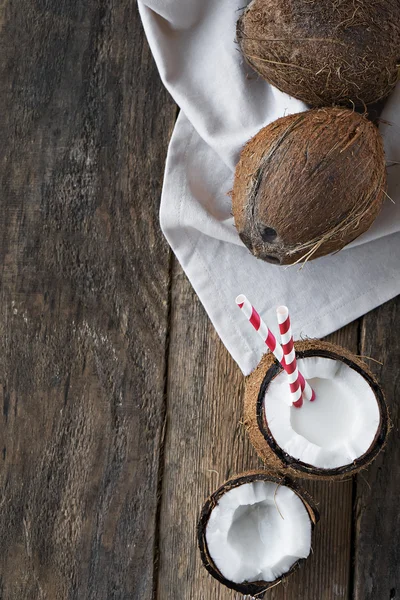 Coconuts with coconut milk on wooden table
