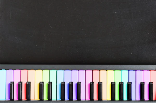 Colorful music keyboard on blackboard background for music schoo