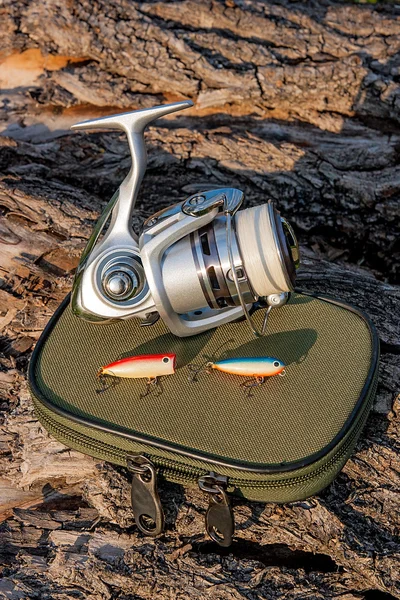 Fishing reel and various kind of baits on the natural background