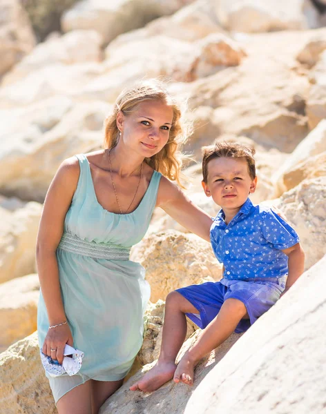 Smiling mother  and her little son. Yellow rocks and stones. Concept of mothers Day. Family outdoors portrait.