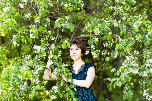 Spring girl portrait. Asian woman smiling happy on sunny summer or spring day outside in flowering tree garden. Pretty mixed race Caucasian or Chinese Asian young woman outdoors.