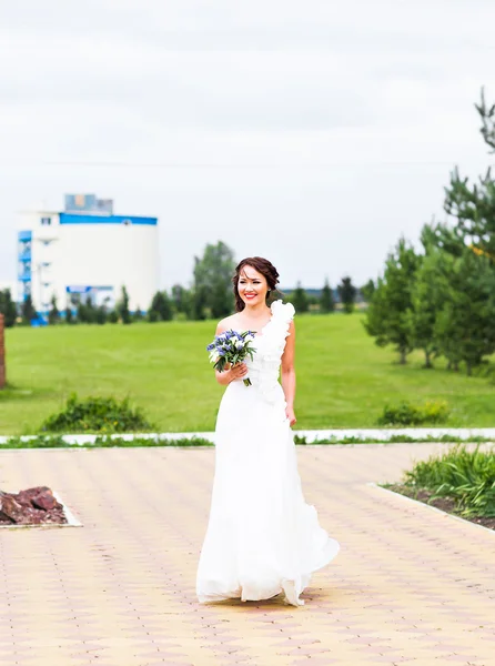 Bride holding bouquet of white calla lilies and blue flowers