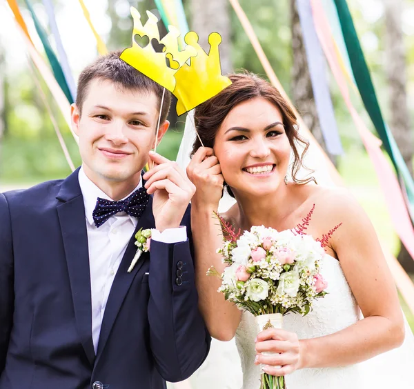 April Fools Day. Wedding couple posing with crown, mask.