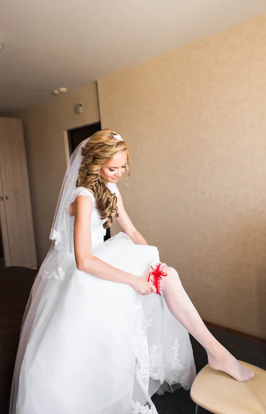 Bride putting a wedding garter on her leg