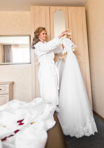 The bride in white bathrobe. Wedding preparations.