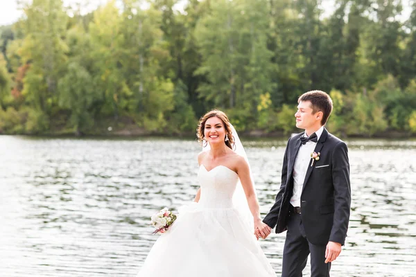 Wedding couple walking  near lake.
