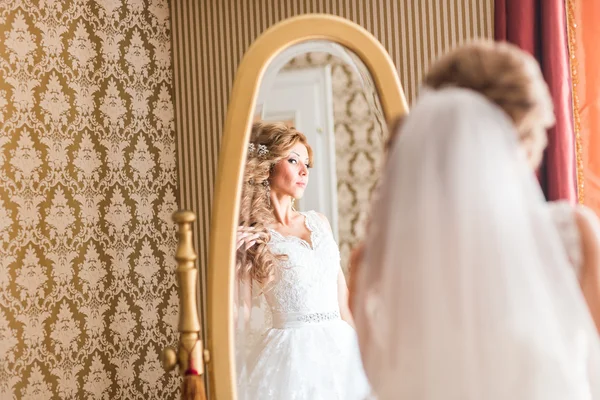 Young bride looks at herself in the mirror