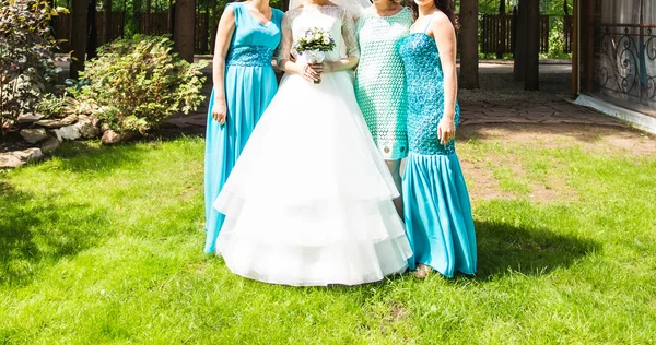 Bride with bridesmaids on the park in wedding day