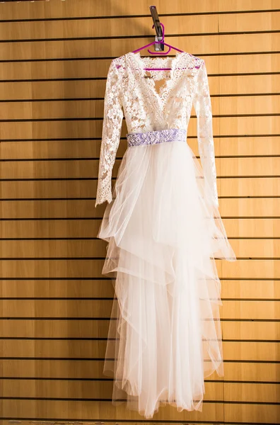 The perfect wedding dress on a hanger in room of  bride