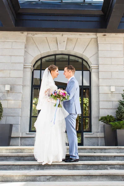 Bride and groom at wedding Day walking Outdoors. Happy Newlyweds  embracing. Loving couple.