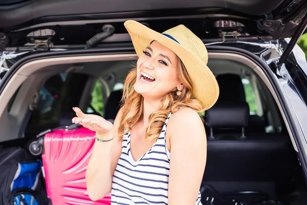 Vacation, Travel - young woman ready for the traveling. suitcases and car