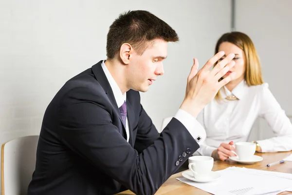 Young business colleagues discussing work on a laptop computer in co-working space, corporate businesspeople