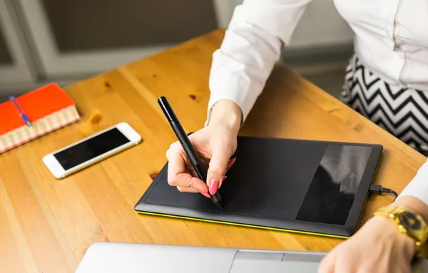 Close-up of female designer using graphics tablet