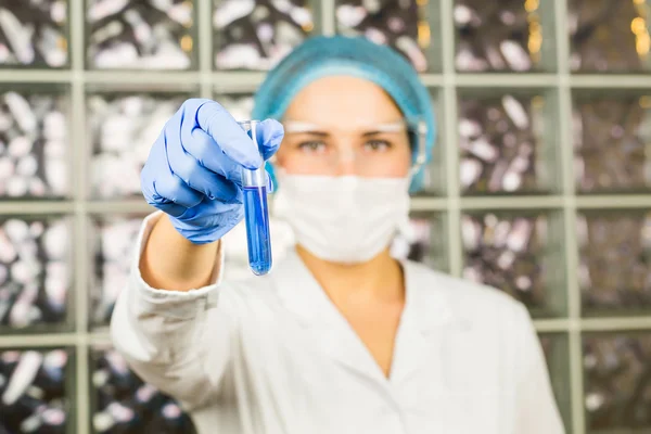 Science, chemistry, biology, medicine, people concept - close-up of female scientist holding tube with sample making and test or research in clinical laboratory
