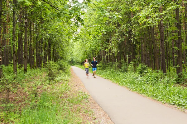 Young Couple Running In Wooded Forest Area - Fitness Healthy Lifestyle Concept