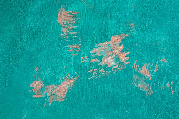 Fragment of the old wall, painted bright turquoise paint, cracked over time.