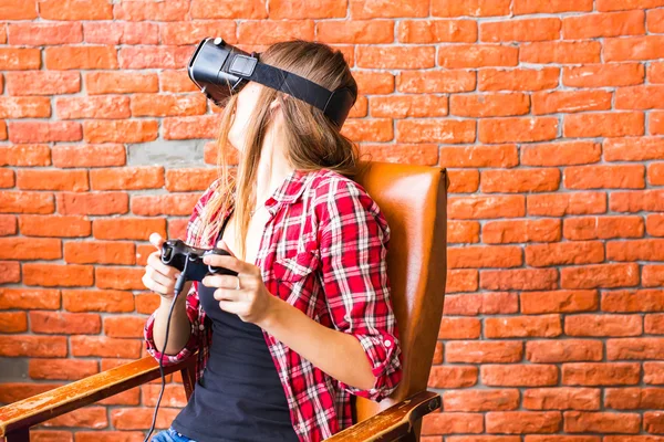 Technology, gaming, entertainment and people concept - young woman with virtual reality headset, controller gamepad playing racing video game.