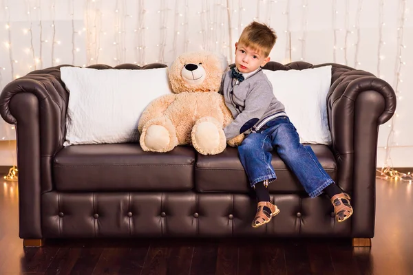 Portrait of little boy with teddy bear at home