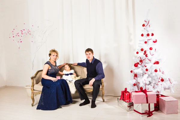 Christmas family of three  persons and fir tree with gift boxes
