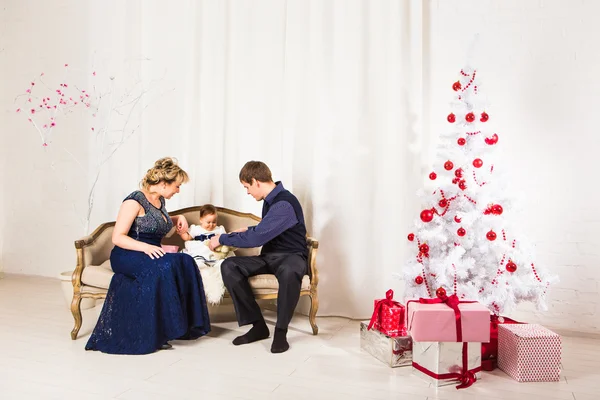 Christmas family of three  persons and fir tree with gift boxes