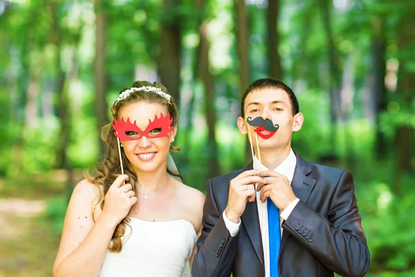 April Fools Day. Wedding couple posing with stick lips, mask.