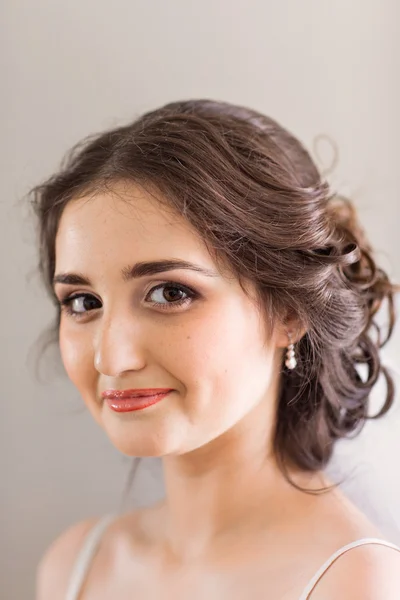 Beautiful young bride with wedding makeup and hairstyle in bedroom, newlywed woman final preparation for wedding. Happy Bride waiting groom. Marriage Wedding day moment. Bride portrait soft focus