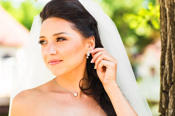 Portrait of beautiful young woman with earing. Make up and hair style. Wedding bride make up.