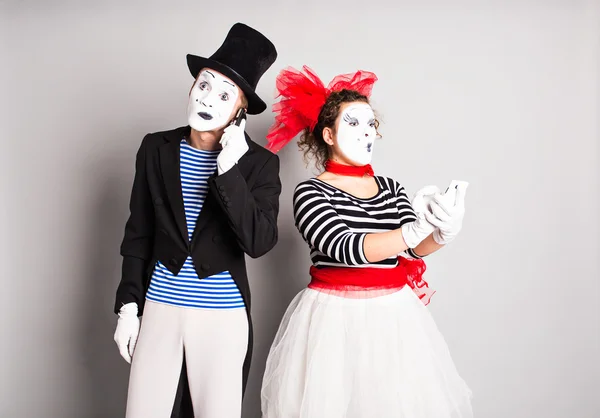 Funny couple of mimes talking by the phones. Concept of  April Fools Day.