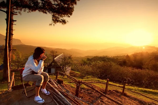 Woman watching sunset with a cup of warn drink
