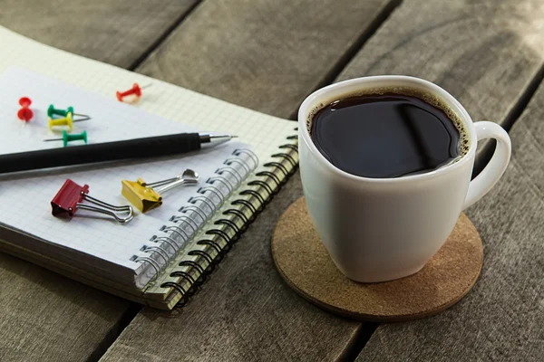 Black coffee and notebook on the desktop