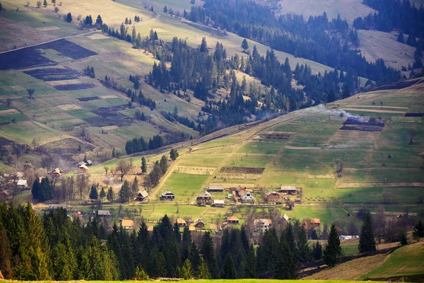 Sunny spring in mountain village. Fields and hills
