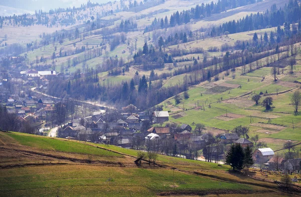 Sunny spring in mountain village. Fields and hills