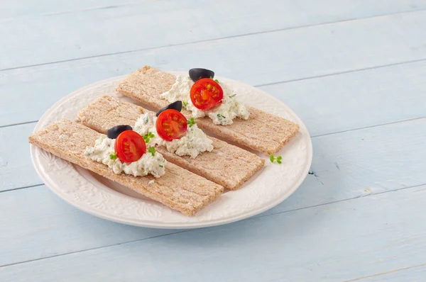 Dry diet crisp breads with cheese, cherry tomatoes and olives