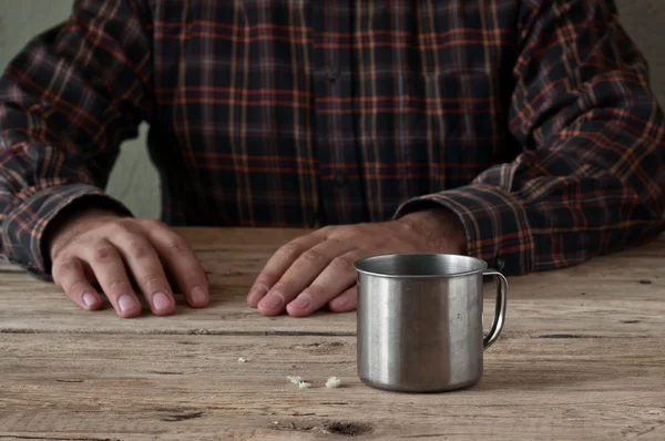 Empty steel cup bread crumbs on a wooden table closeup